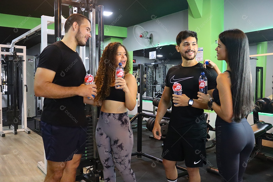 Belos casais segurando copos de água sobre uma academia