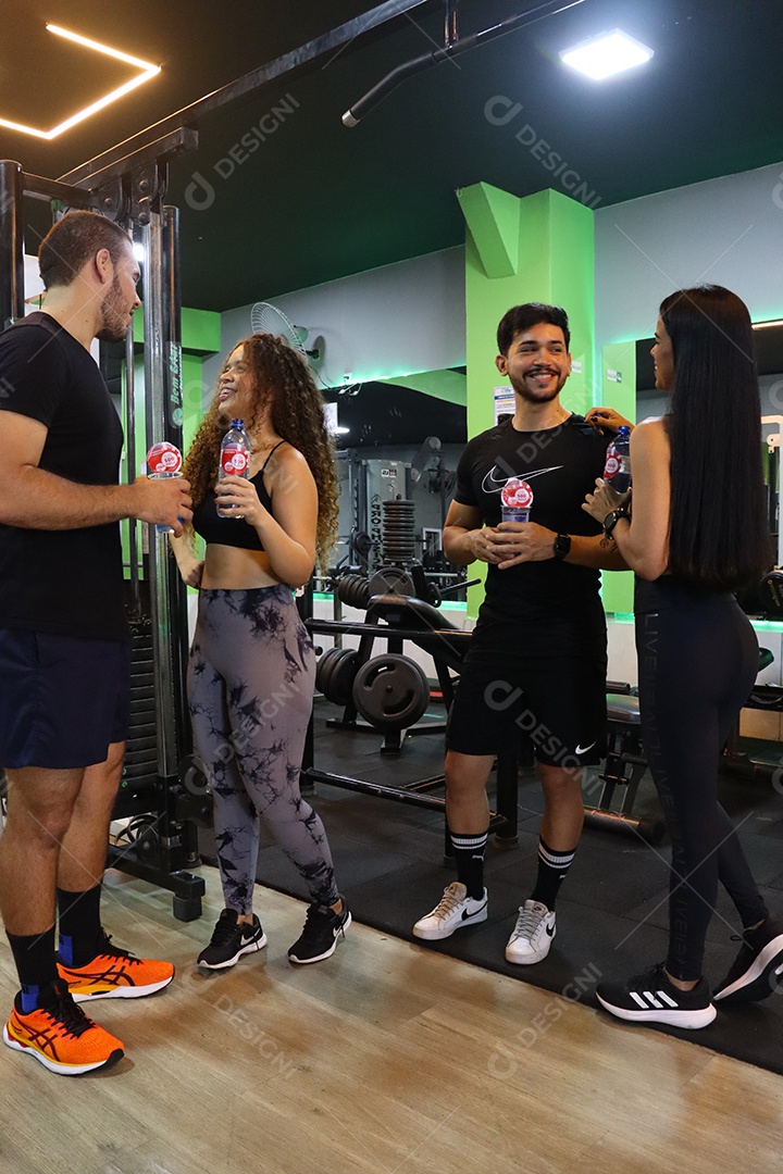 Belos casais segurando copos de água sobre uma academia