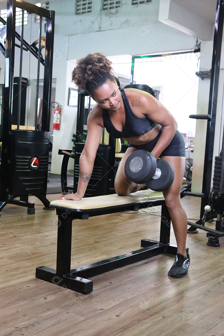 Bela mulher fazendo exercicíos sobre uma academia