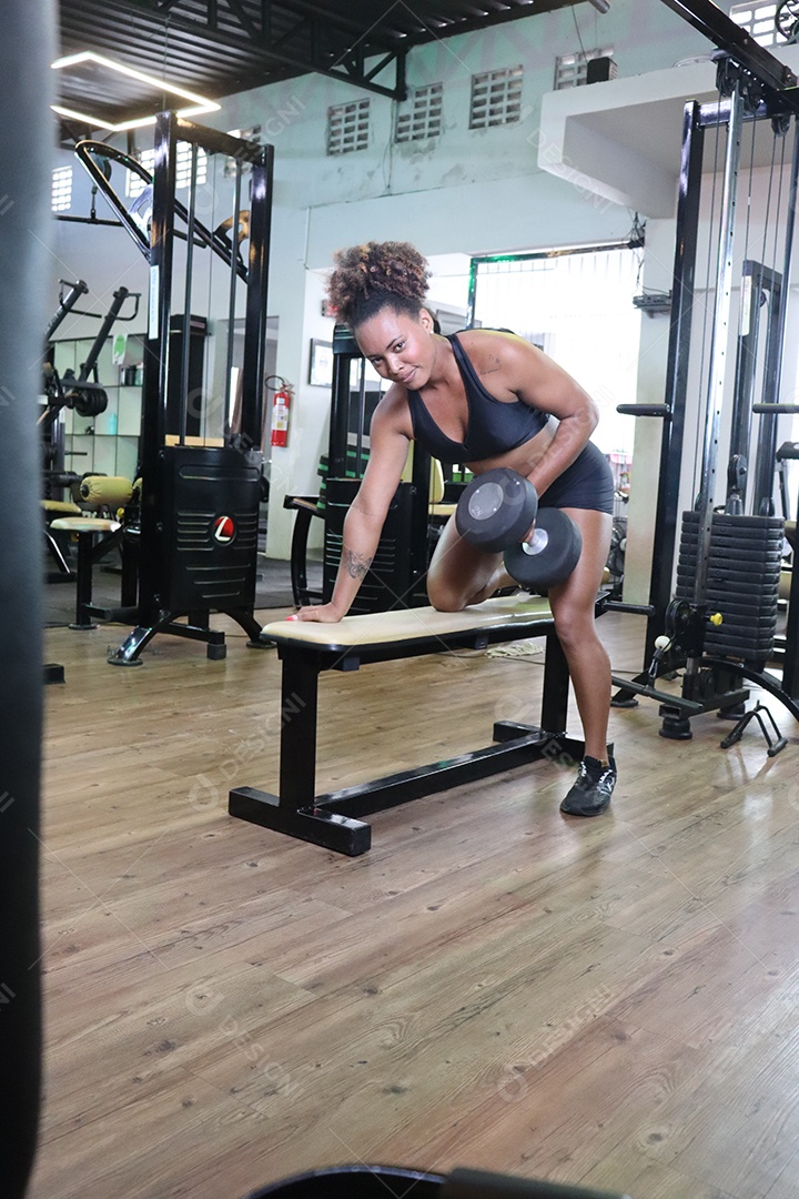 Bela mulher fazendo exercicíos sobre uma academia