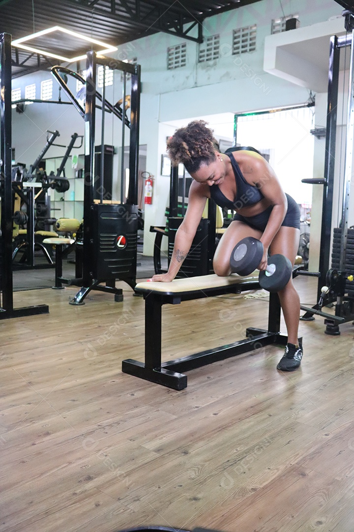 Bela mulher fazendo exercicíos sobre uma academia
