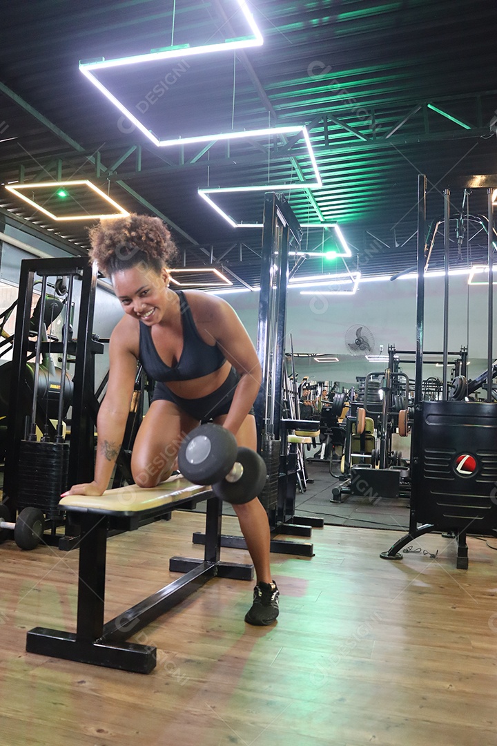 Bela mulher fazendo exercicíos sobre uma academia