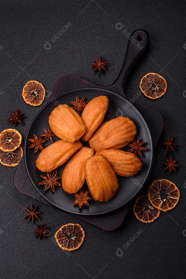 Biscoitos tradicionais de madeleine francesa com sabor de nozes fundo escuro de concreto