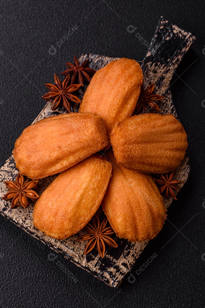 Biscoitos tradicionais de madeleine francesa com sabor de nozes fundo escuro de concreto