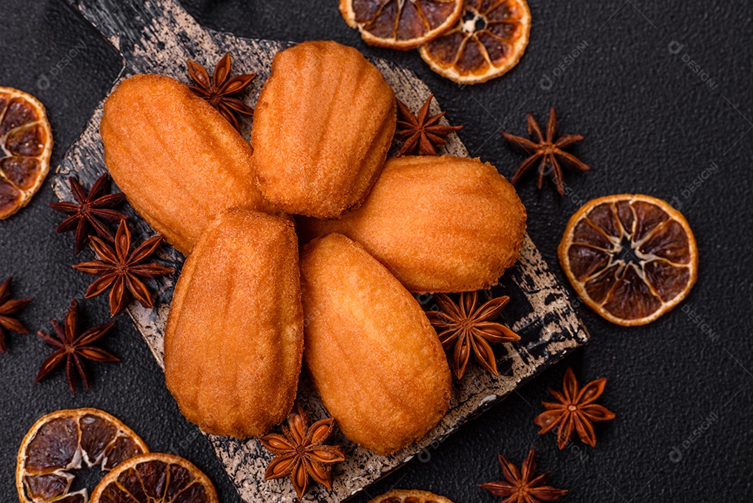 Biscoitos tradicionais de madeleine francesa com sabor de nozes fundo escuro de concreto