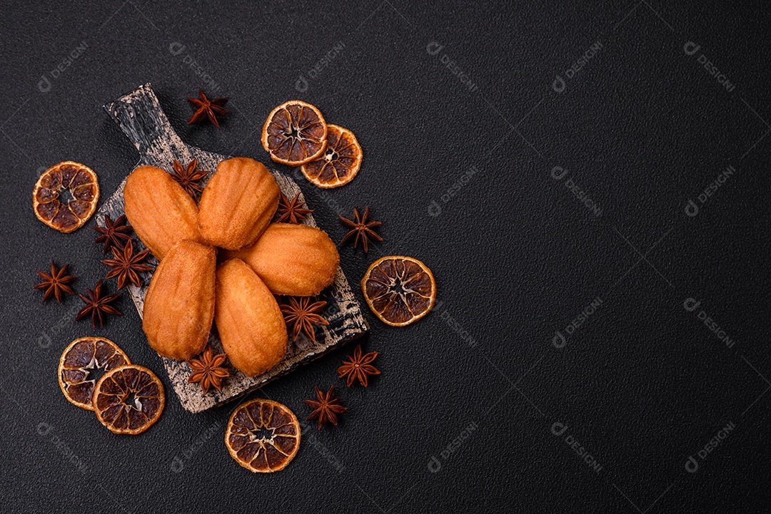 Biscoitos tradicionais de madeleine francesa com sabor de nozes fundo escuro de concreto