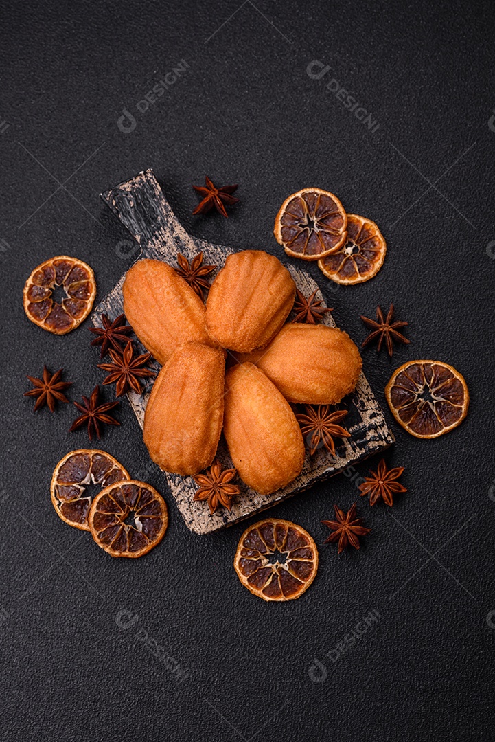 Biscoitos tradicionais de madeleine francesa com sabor de nozes fundo escuro de concreto