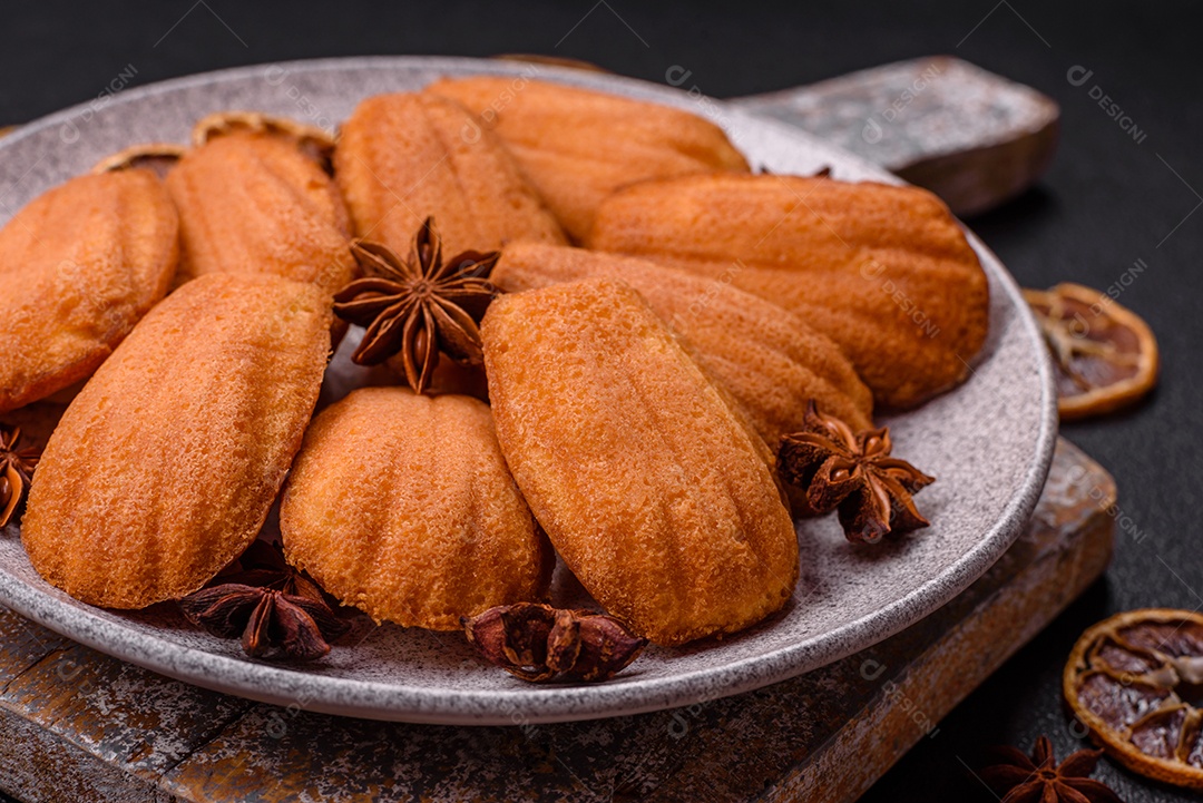 Biscoitos tradicionais de madeleine francesa com sabor de nozes fundo escuro de concreto