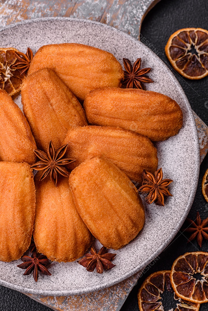 Biscoitos tradicionais de madeleine francesa com sabor de nozes fundo escuro de concreto