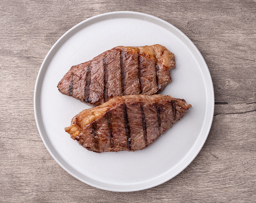 A imagem mostra dois pedaços de picanha bovina grelhados em um prato branco