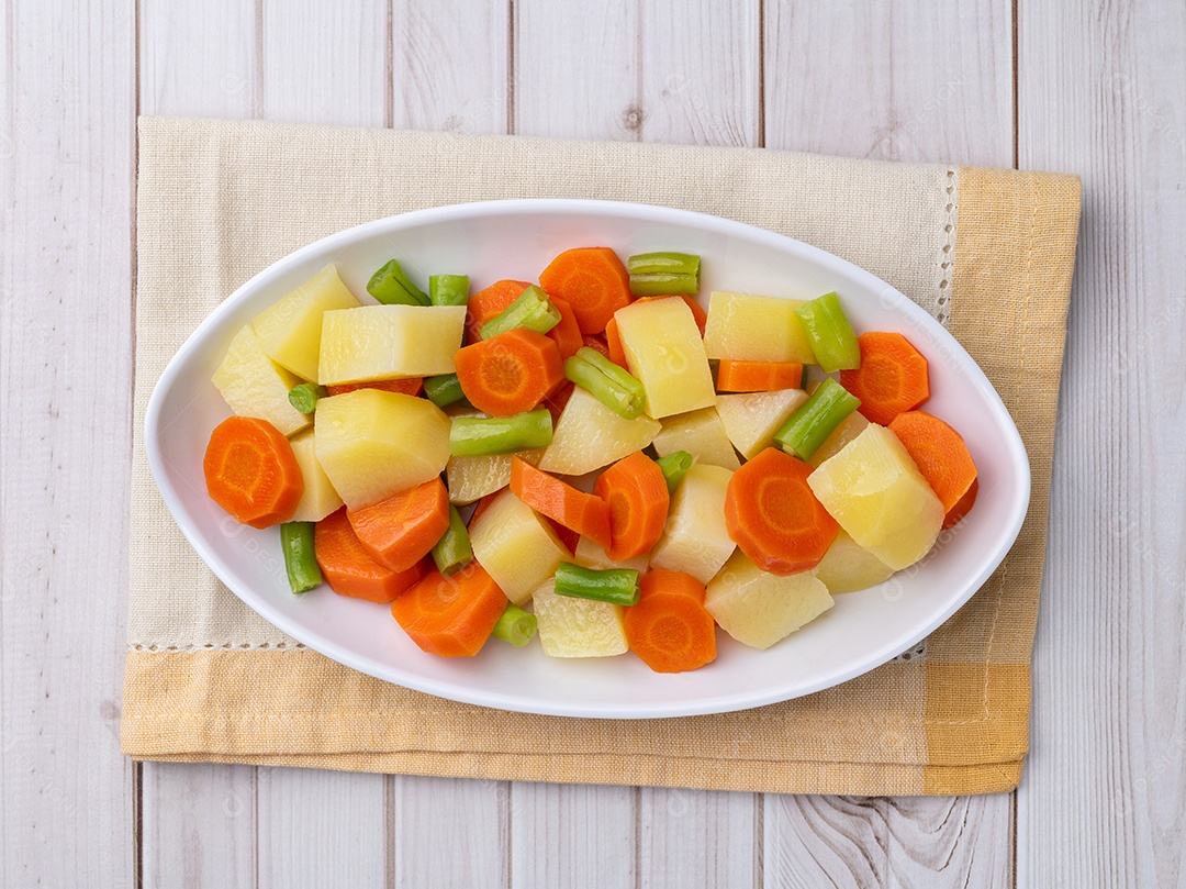 Prato de legumes cozidos em uma mesa de madeira