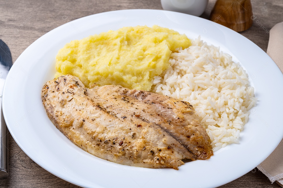 A imagem mostra um prato de filé de peixe acompanhado de arroz e purê de batata.