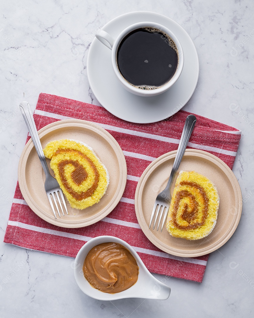 A imagem mostra fatias de rocambole servidas com café e um molho cremoso, possivelmente doce de leite ou caramelo.
