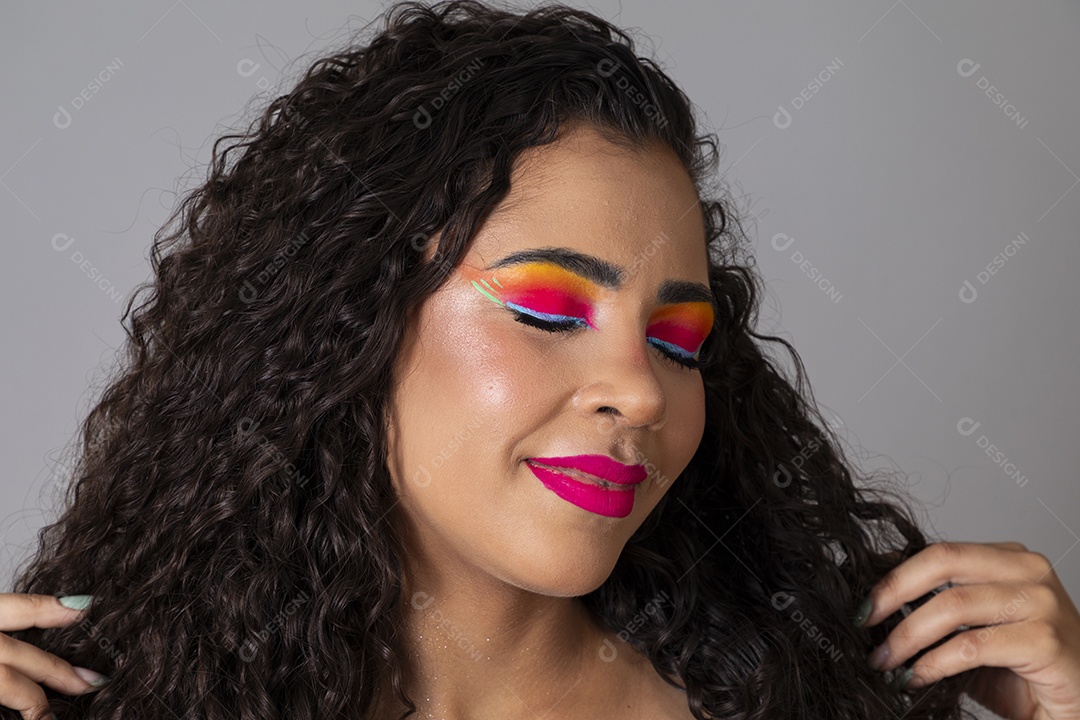 Linda morena do cabelo cacheado sorridente maquiada sobre fundo isolado