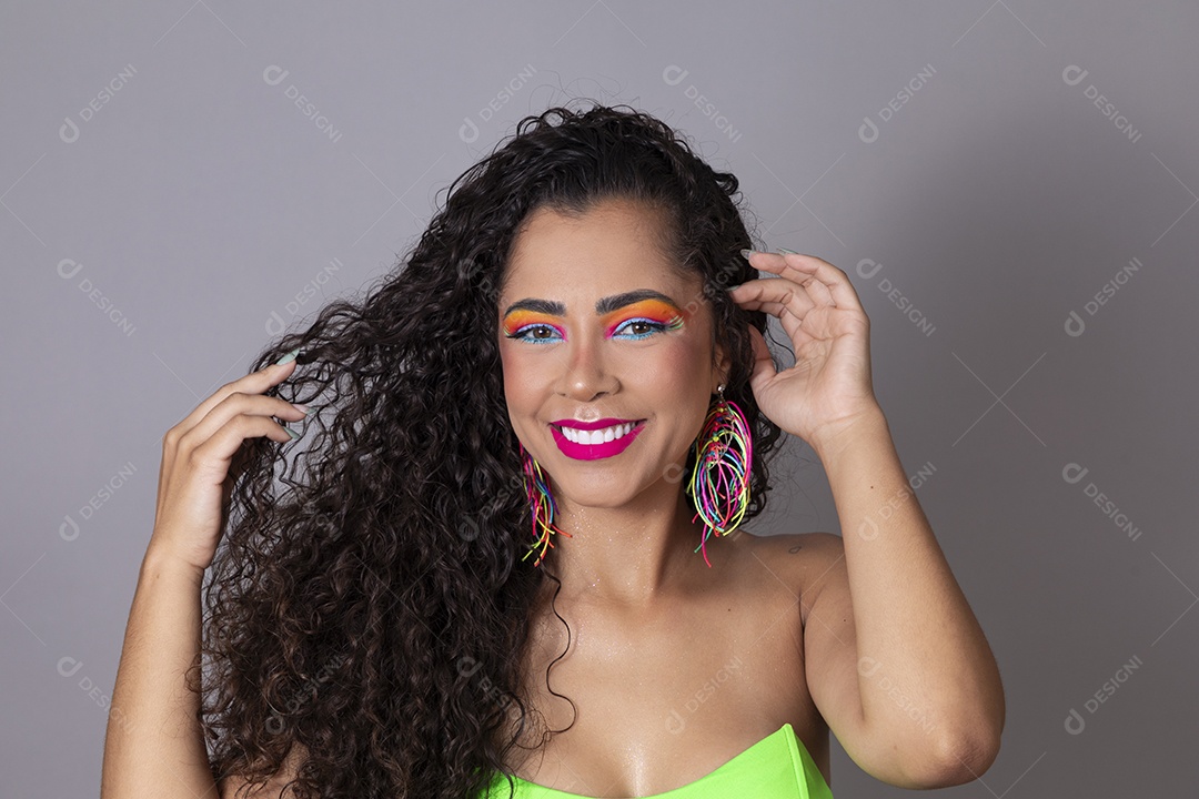 Linda morena do cabelo cacheado sorridente maquiada sobre fundo isolado
