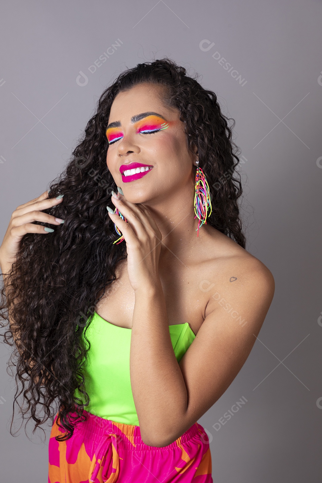 Linda morena do cabelo cacheado sorridente fantasiada sobre fundo isolado