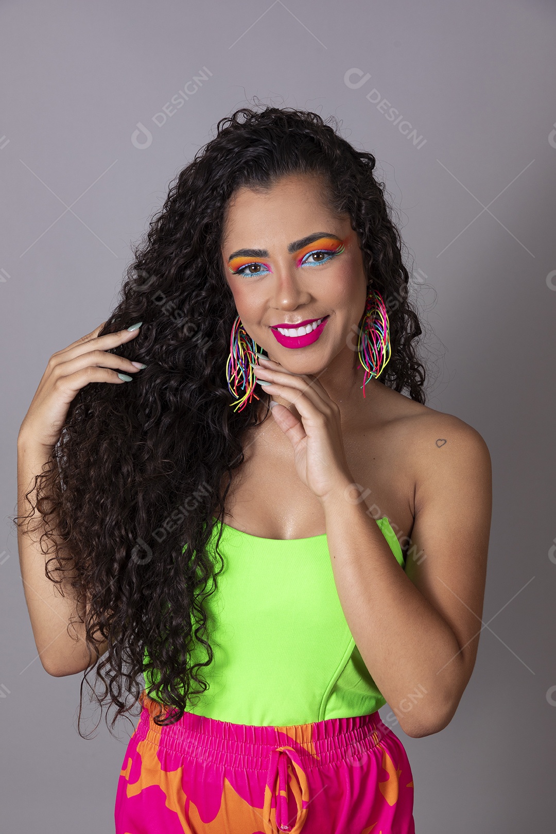 Linda morena do cabelo cacheado sorridente fantasiada sobre fundo isolado