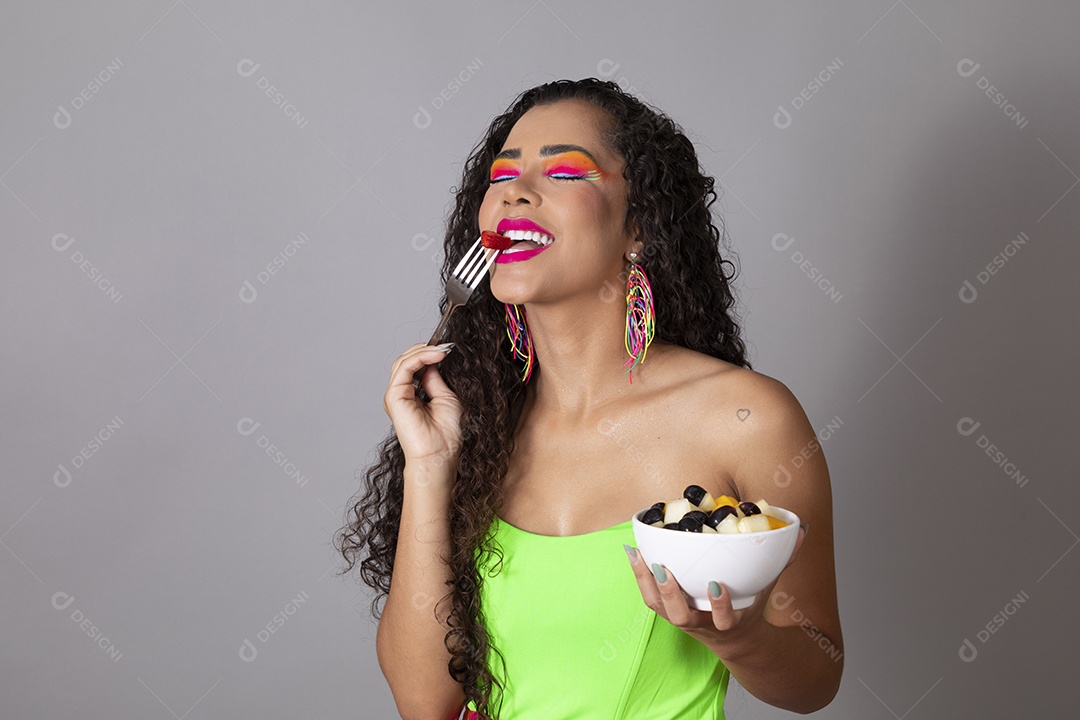 Linda morena do cabelo cacheado sorridente fantasiada segurando tijela de sorvete sobre fundo isolado