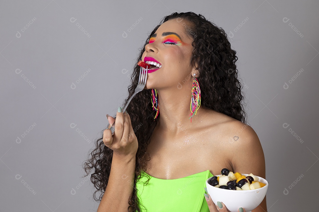 Linda morena do cabelo cacheado sorridente fantasiada segurando tijela de sorvete sobre fundo isolado