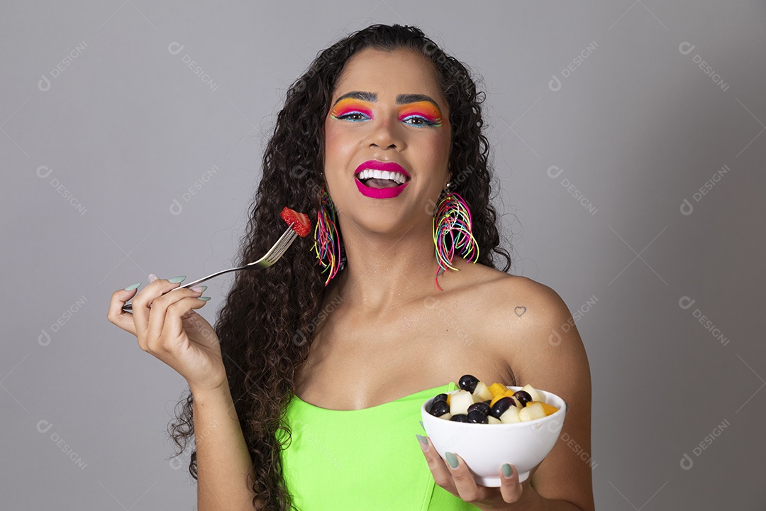 Linda morena do cabelo cacheado sorridente fantasiada segurando tijela de sorvete sobre fundo isolado