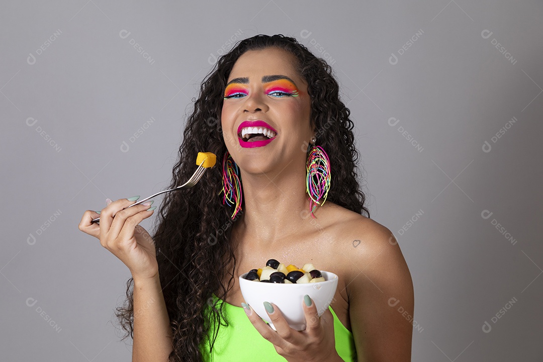 Linda morena do cabelo cacheado sorridente fantasiada segurando tijela de sorvete sobre fundo isolado