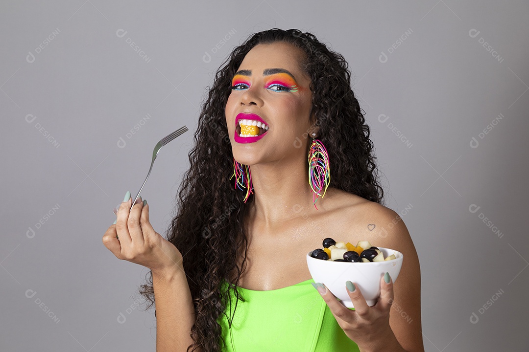 Linda morena do cabelo cacheado sorridente fantasiada segurando tijela de sorvete sobre fundo isolado