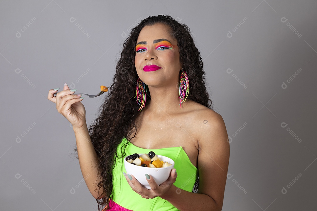 Linda morena do cabelo cacheado sorridente fantasiada segurando tijela de sorvete sobre fundo isolado