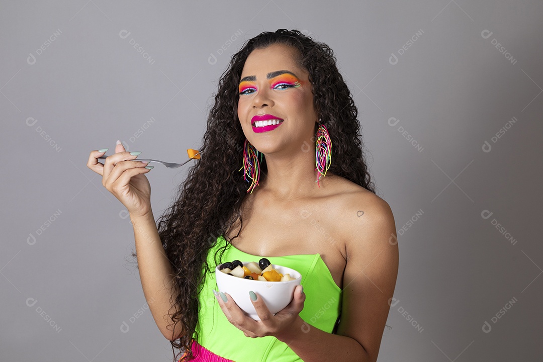 Linda morena do cabelo cacheado sorridente fantasiada segurando tijela de sorvete sobre fundo isolado