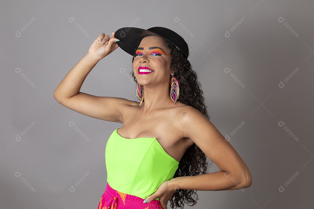 Linda morena do cabelo cacheado sorridente maquiada usando boné sobre fundo isolado