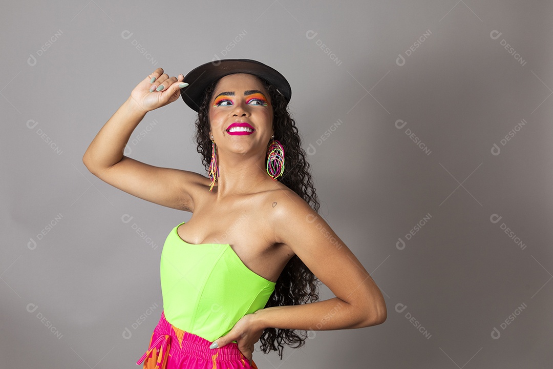 Linda morena do cabelo cacheado sorridente maquiada usando boné sobre fundo isolado