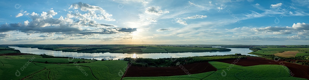 Vista aérea de campos de cana de açúcar às margens do rio Tietê ao anoitecer