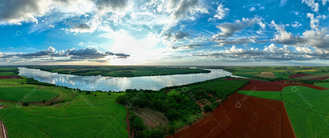 Vista aérea de campos de cana de açúcar às margens do rio Tietê ao anoitecer