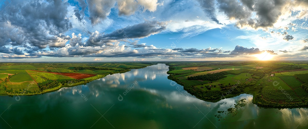 Vista aérea de campos de cana de açúcar às margens do rio Tietê ao anoitecer