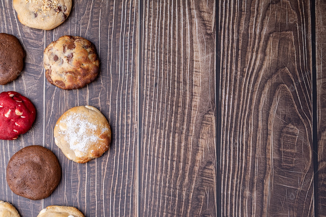 A imagem mostra uma variedade de biscoitos e produtos de panificação dispostos sobre uma superfície de madeira escura