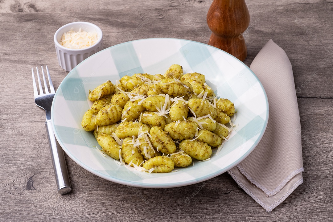 A imagem mostra um prato de nhoque, uma massa italiana tradicional.