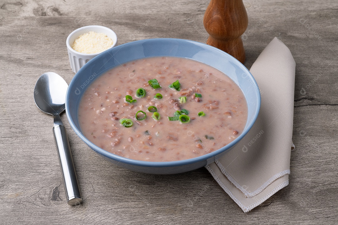 A imagem mostra uma tigela de sopa de feijão com macarrão