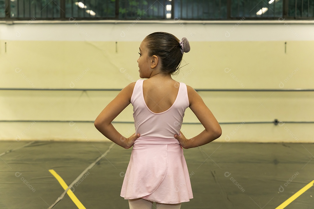 Linda menina sorridente praticando balé sobre escola de dança