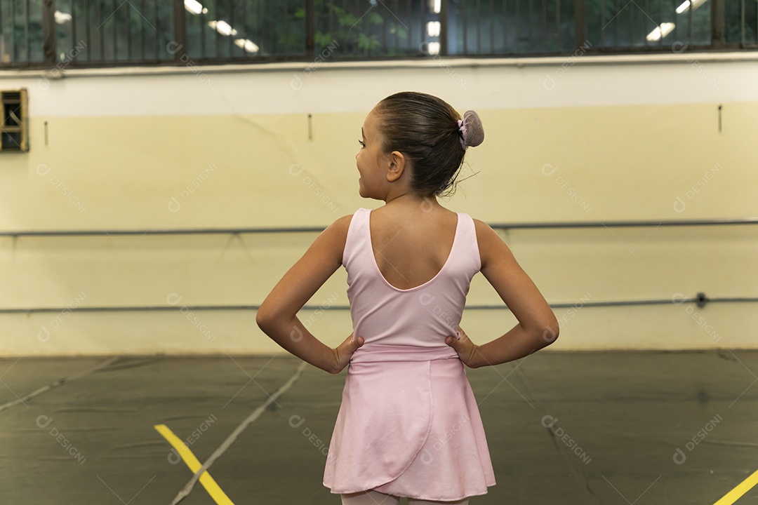 Linda menina sorridente praticando balé sobre escola de dança