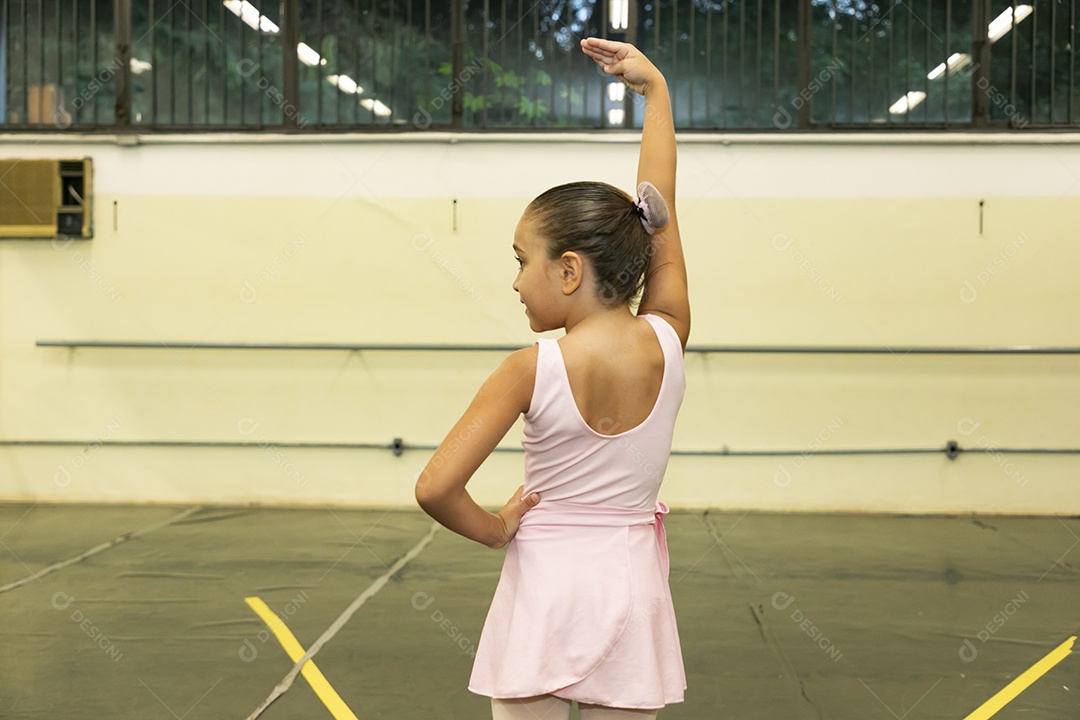 Linda menina sorridente praticando balé sobre escola de dança