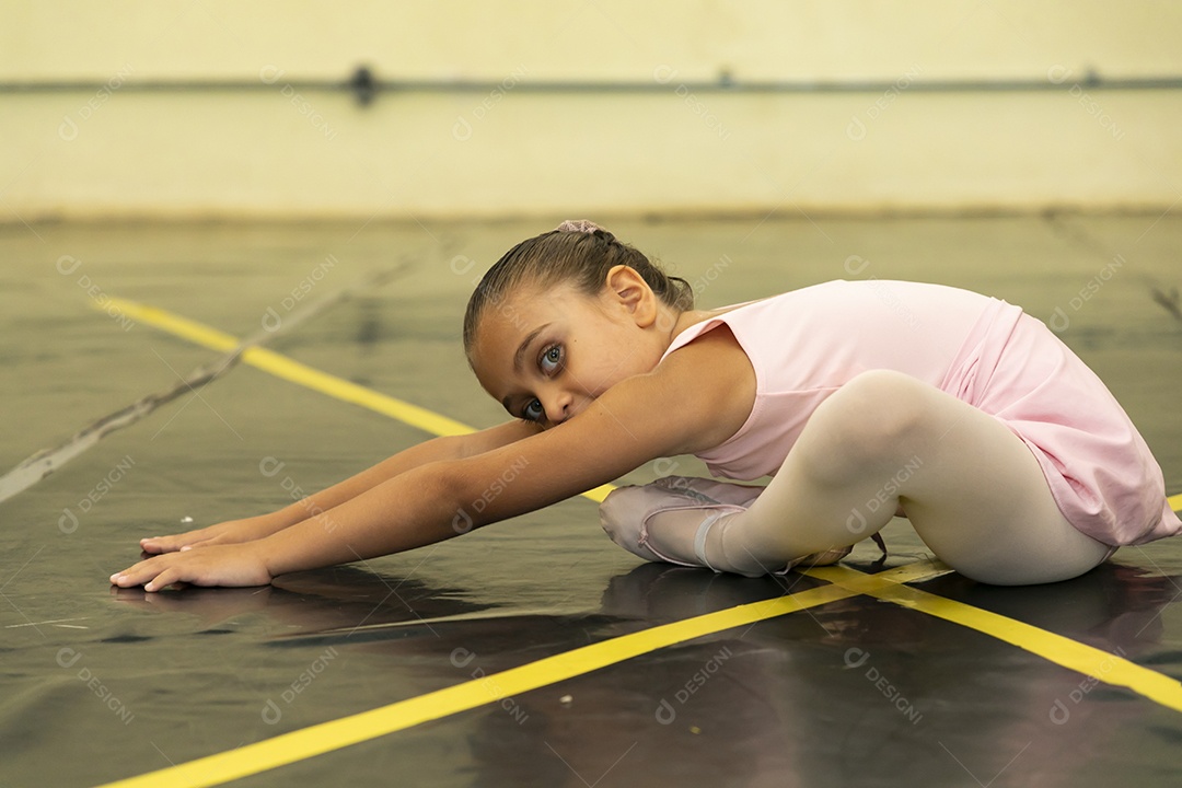 Linda menina sorridente praticando balé sobre escola de dança