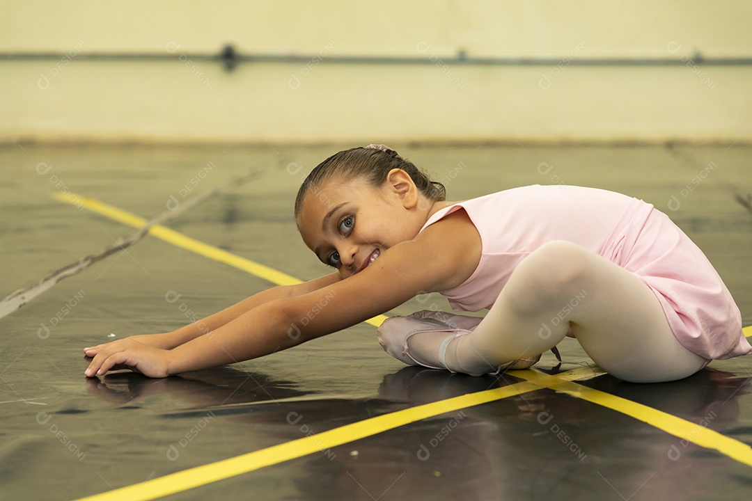 Linda menina sorridente praticando balé sobre escola de dança