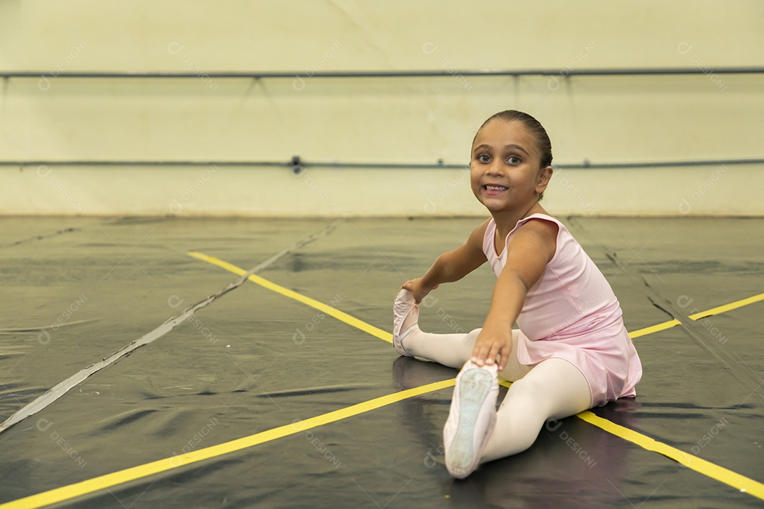 Linda menina sorridente praticando balé sobre escola de dança