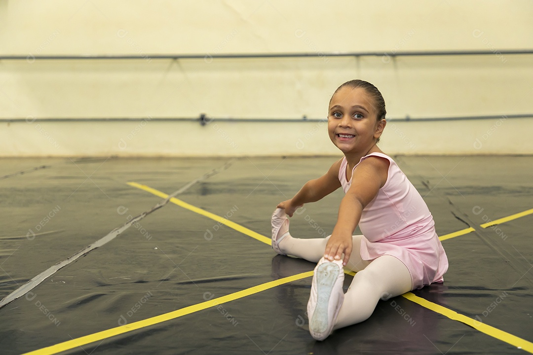 Linda menina sorridente praticando balé sobre escola de dança