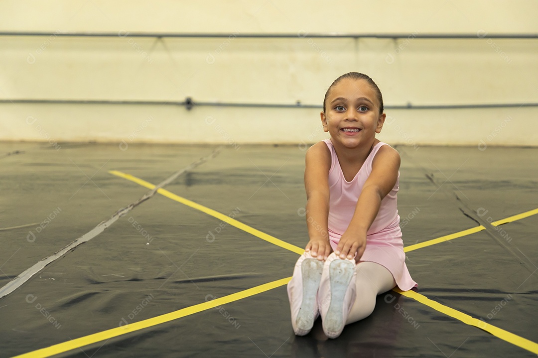 Linda menina sorridente praticando balé sobre escola de dança