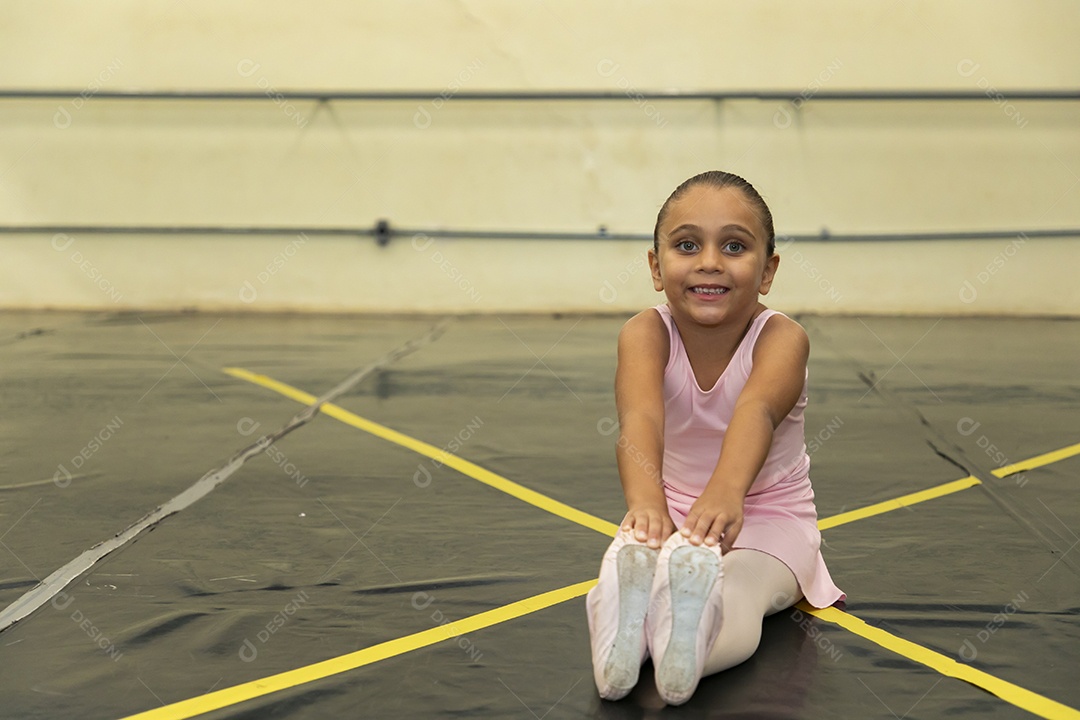 Linda menina sorridente praticando balé sobre escola de dança