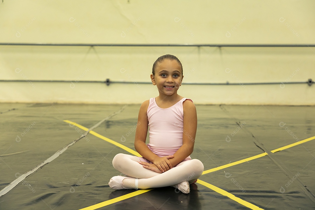 Linda menina sorridente praticando balé sobre escola de dança