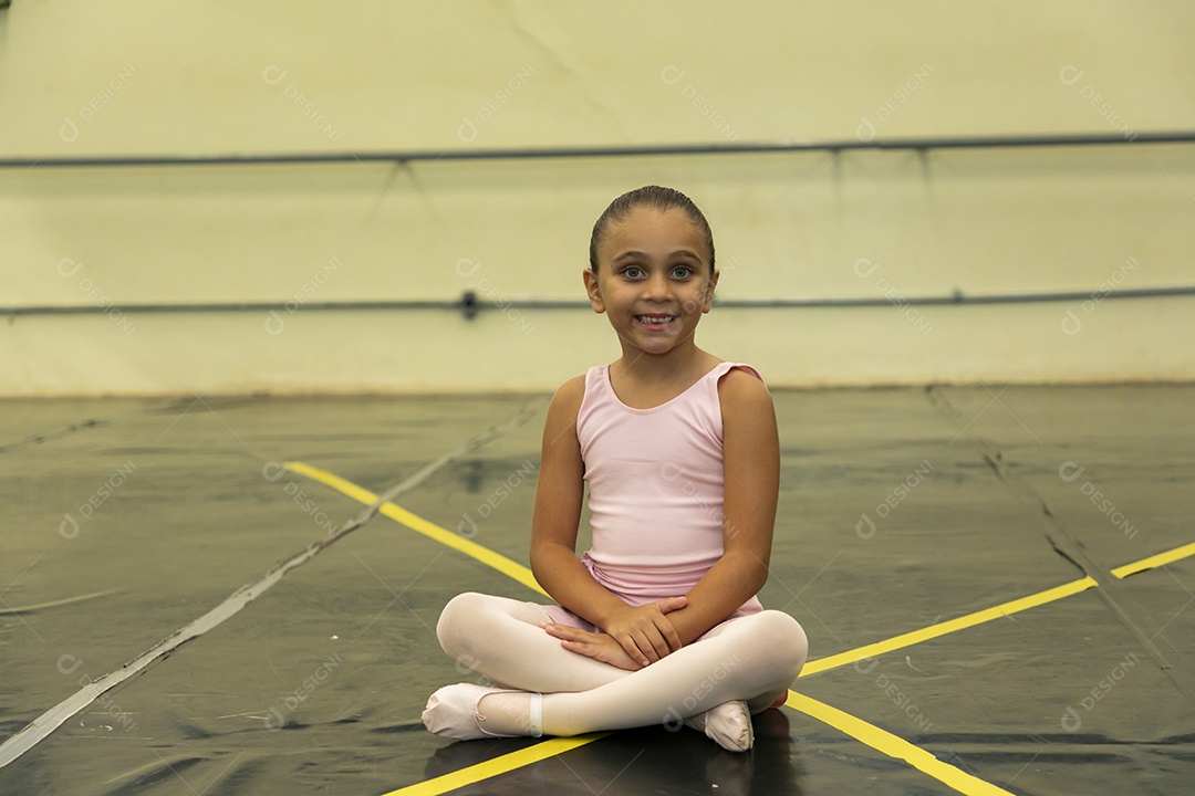 Linda menina sorridente praticando balé sobre escola de dança