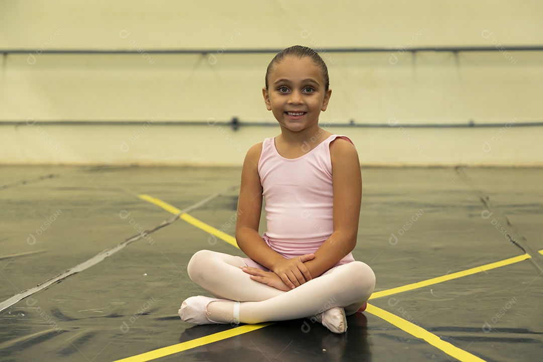 Linda menina sorridente praticando balé sobre escola de dança