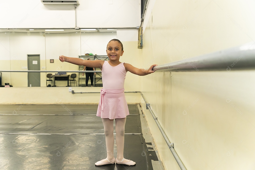 Linda menina sorridente praticando balé sobre escola de dança