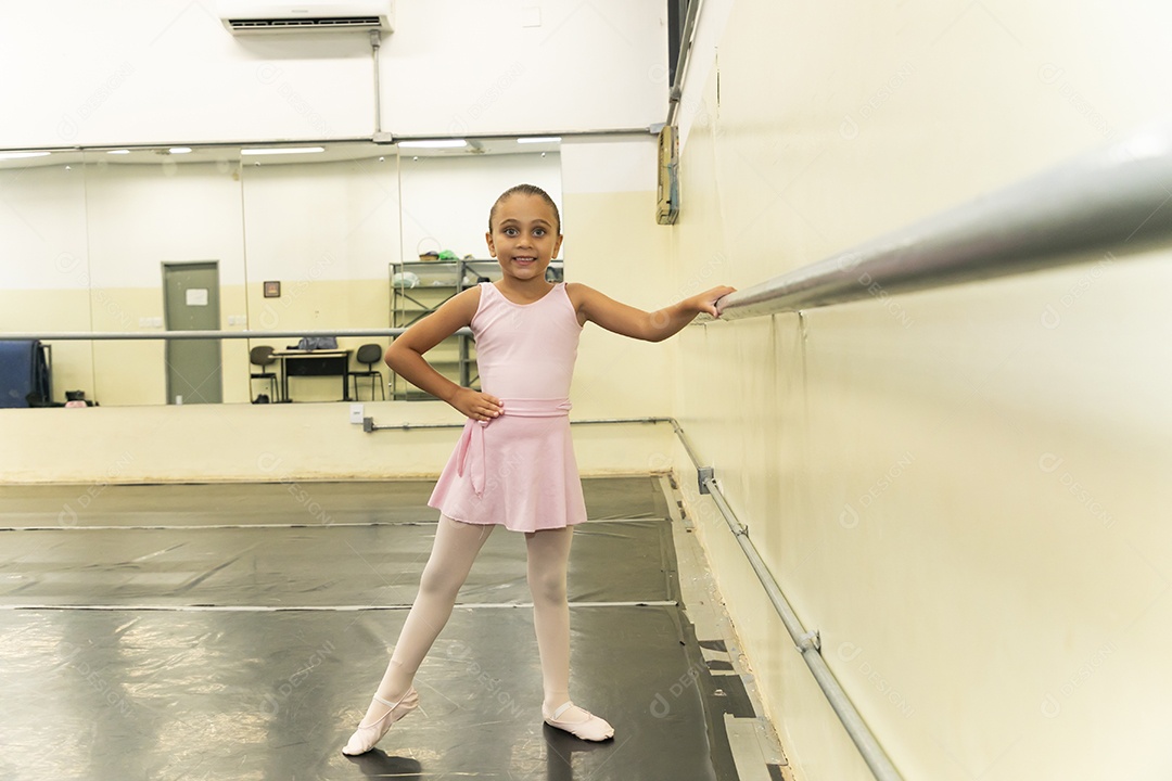 Linda menina sorridente praticando balé sobre escola de dança